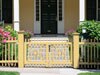 Benjamin Moore&rsquo;s straw (2154-50) paint color on this fence blends well with white trim.