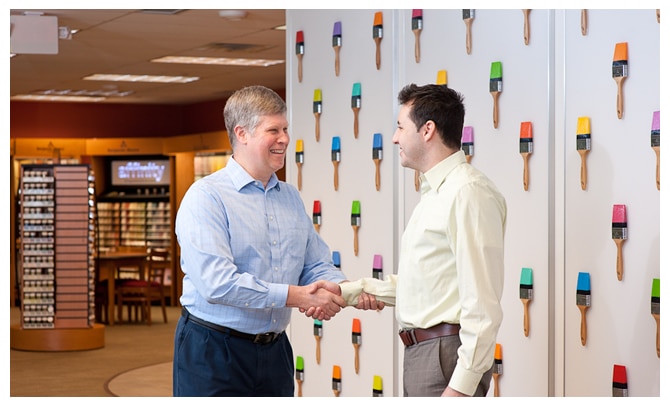 Deux hommes se serrent la main, heureux de leur carrière chez Benjamin Moore.