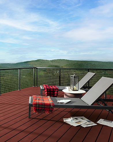 Dos tumbonas plegables con mantas rojas sobre una espaciosa terraza teñida con Woodluxe® liso en color Secoya ES-20.