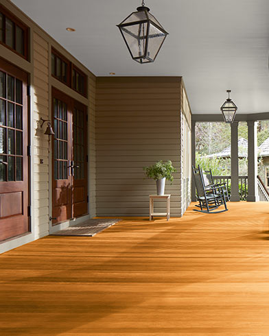 Grande véranda couverte avec magnifique plancher enduit de teinture Woodluxe au fini translucide de couleur Cèdre ES-40.