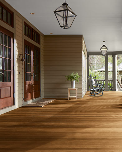 Grande véranda couverte avec magnifique plancher enduit de teinture Woodluxe au fini translucide de couleur Châtaignon ES-65.