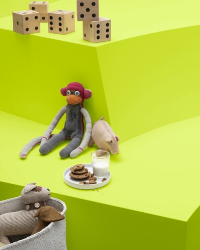Bright Lime-painted shelves are filled with children's toys, including a sock monkey, knit animals and large dice.