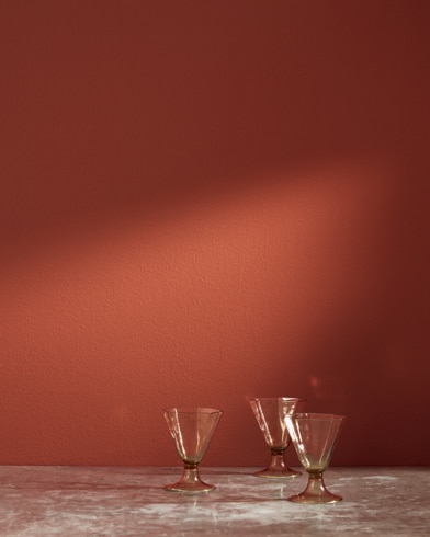 Three glass cups in front of a Country Redwood-painted wall.