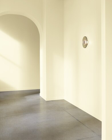 An arched hallway in a modern home is painted Pale Celery.