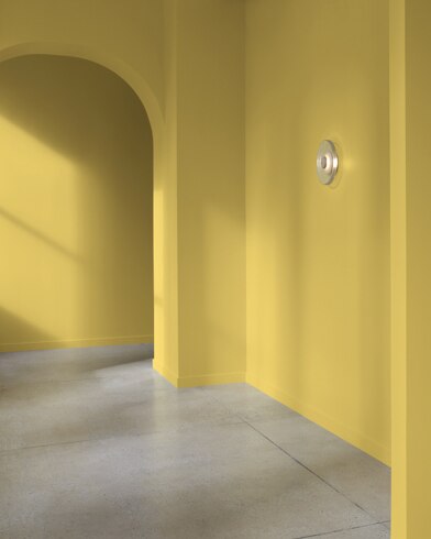 An arched hallway in a modern home is painted Gibson Gold.