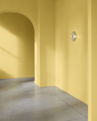 An arched hallway in a modern home is painted Golden Thread.