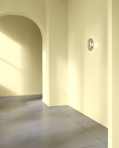 An arched hallway in a modern home is painted Luminaire.
