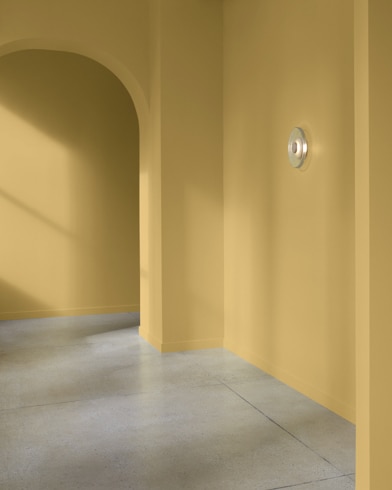 An arched hallway in a modern home is painted Millington Gold.