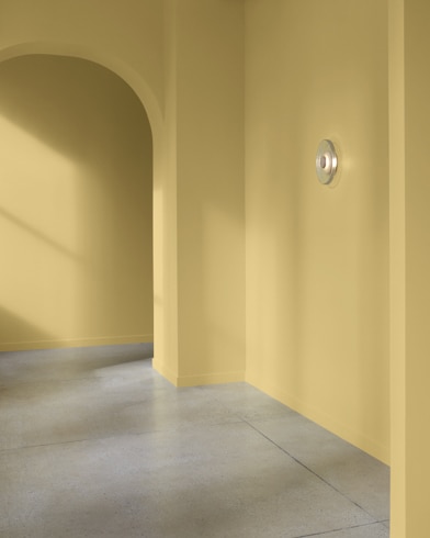 An arched hallway in a modern home is painted Princeton Gold.