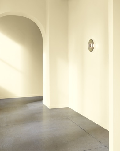 An arched hallway in a modern home is painted Vanilla Cookie.