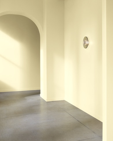 An arched hallway in a modern home is painted Yellow Iris.