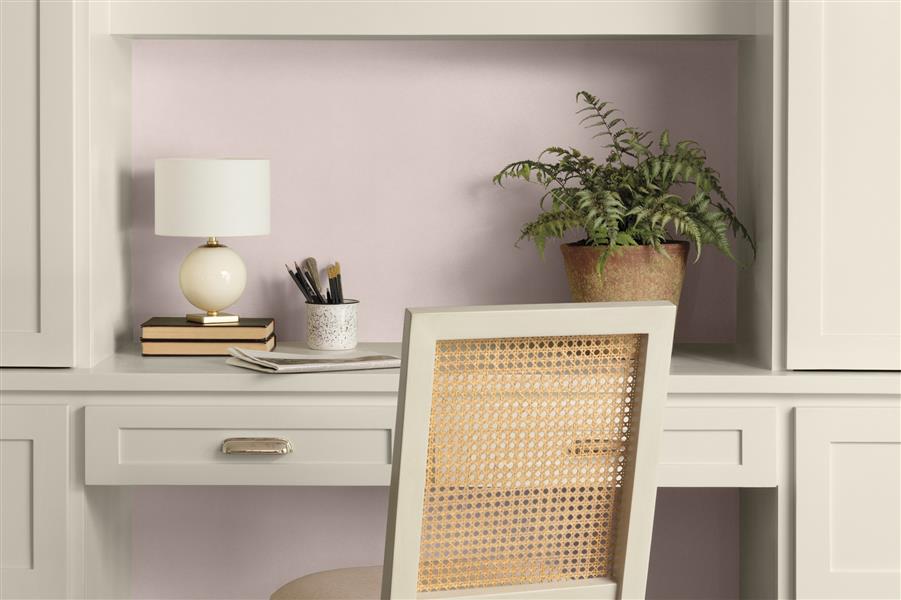 A built-in desk unit painted in White Down OC-131, featuring brass cup handles. The walls are painted in Wild Aster 1240.
