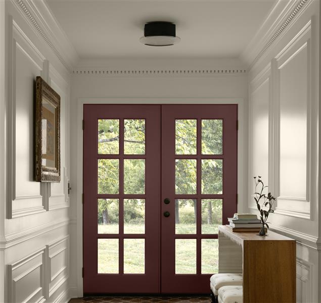 A view of a hallway looking towards a glazed door painted in Townsend Harbour Brown HC-64. Surrounding walls and ceiling painted in White Down OC-131. From the Benjamin Moore Colour Trends 2027 collection.