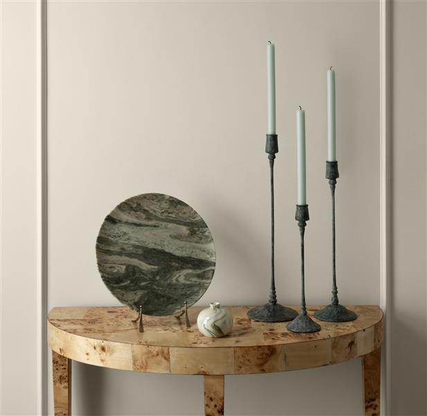 A console table dressed with candles and ornaments in front of a panelled wall painted in White Down OC-131, part of the Colour Trends 2027 collection.