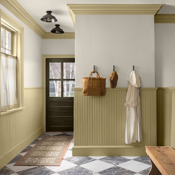 A paneled hallway with Shakespeare Tan 228 featuring on the lower walls, coving and woodwork. The upper walls and ceiling features White Down OC-131 while the doors is painted with Durango 2137-30, all part of the Colour Trends 2027 collection.